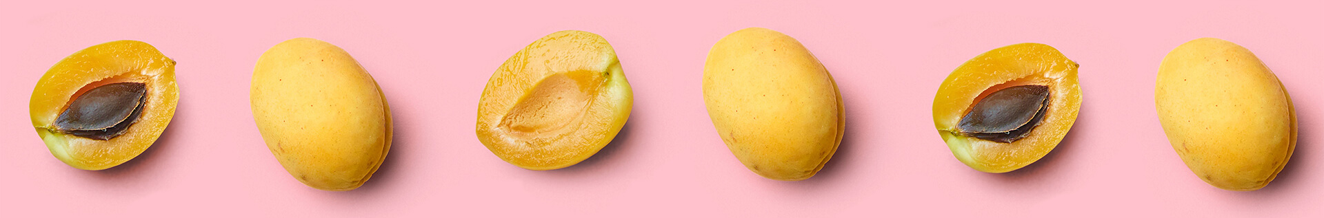 Row of sweet lemons against a pink background
